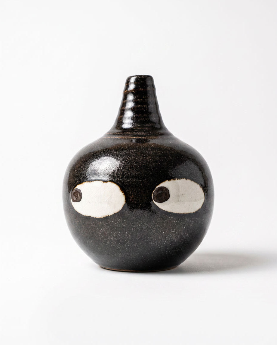 Black ceramic bud vase with two large white eyes, handmade in Korea