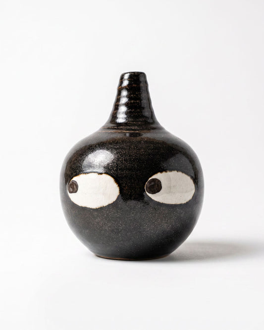Black ceramic bud vase with two large white eyes, handmade in Korea